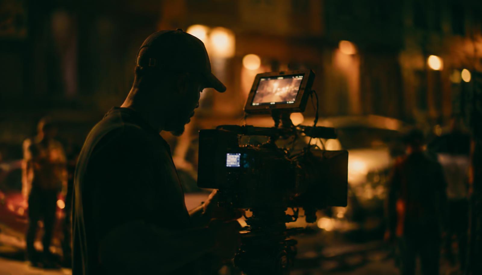 filmmaker operating a cinema camera at night